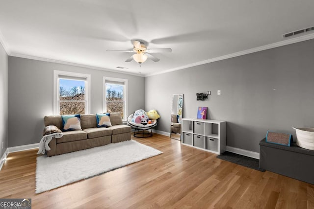 living room featuring baseboards, visible vents, and light wood finished floors