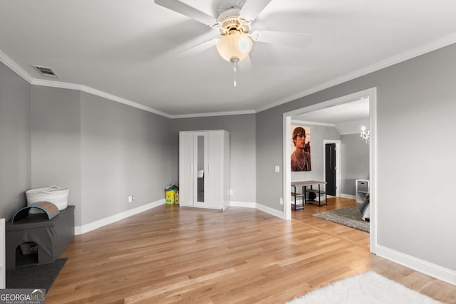 living room with visible vents, ornamental molding, a ceiling fan, light wood-style floors, and baseboards