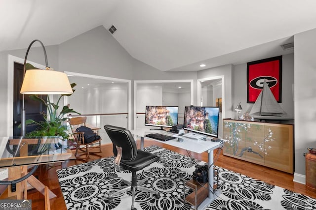 office space featuring visible vents, wood finished floors, and vaulted ceiling