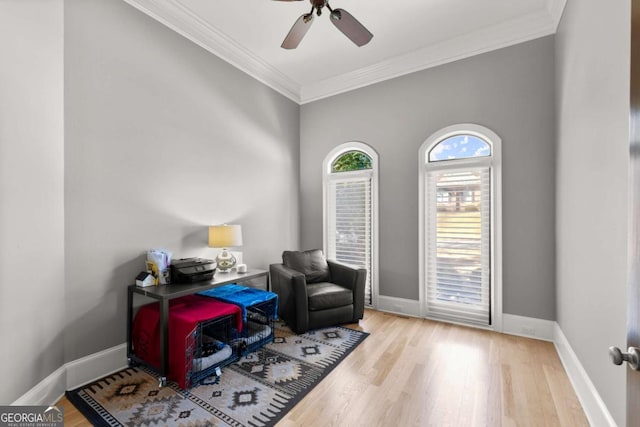 office space featuring ornamental molding, a ceiling fan, baseboards, and wood finished floors