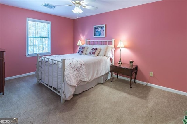 bedroom with baseboards, a ceiling fan, visible vents, and light colored carpet