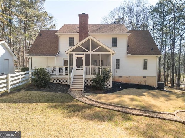 back of house featuring a sunroom, a chimney, crawl space, fence, and a yard