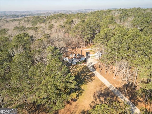 birds eye view of property featuring a forest view