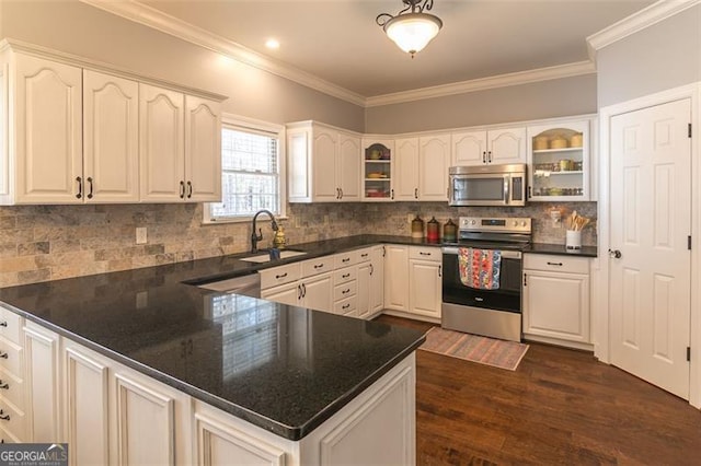 kitchen featuring stainless steel appliances, a peninsula, a sink, and glass insert cabinets