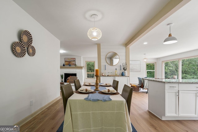 5985 Lakeside Ct, Gainesville, GA 30506 - dining area with light wood-style flooring, a fireplace, and baseboards