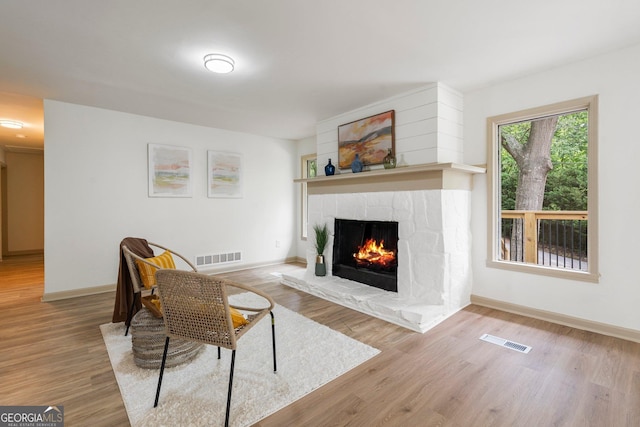 5985 Lakeside Ct, Gainesville, GA 30506 - living area featuring a lit fireplace, wood finished floors, and baseboards