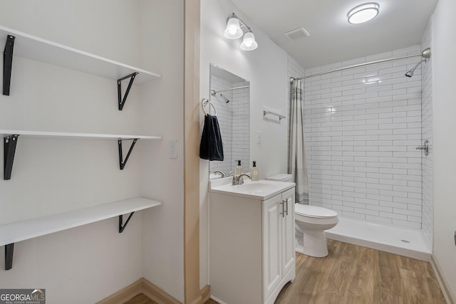 5985 Lakeside Ct, Gainesville, GA 30506 - bathroom featuring a tile shower, toilet, wood finished floors, and vanity