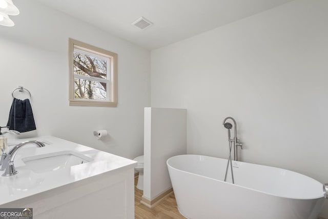 5985 Lakeside Ct, Gainesville, GA 30506 - full bath featuring wood finished floors, a freestanding bath, toilet, and double vanity
