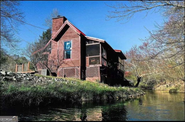 view of side of home featuring a water view and a chimney