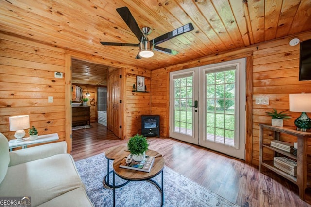 living room with french doors, wooden ceiling, wood finished floors, and wooden walls