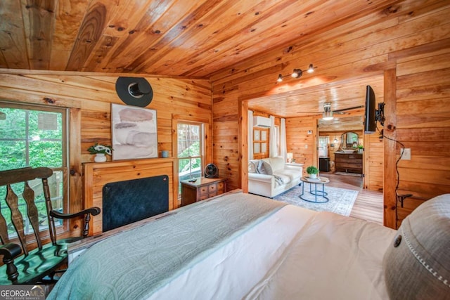 bedroom with multiple windows, wood ceiling, and wooden walls