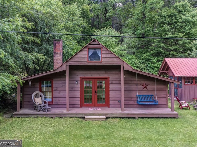 view of outdoor structure featuring french doors and a wooded view