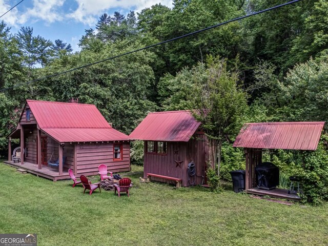 view of yard with a wooden deck, a storage unit, and an outdoor structure