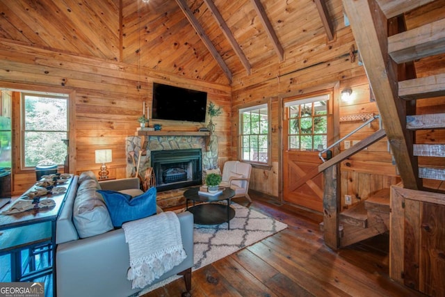 living room with a stone fireplace, wooden walls, wood ceiling, stairway, and wood-type flooring