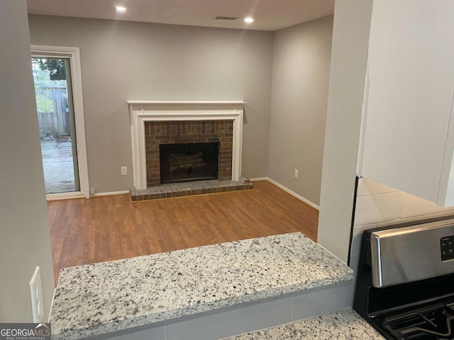 living area with baseboards, a fireplace, wood finished floors, and recessed lighting