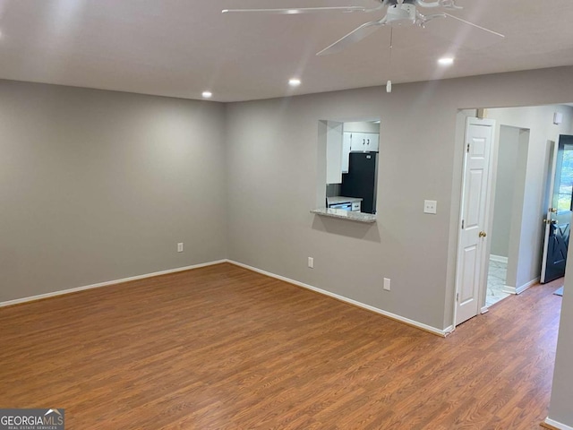 unfurnished room featuring a ceiling fan, recessed lighting, baseboards, and wood finished floors