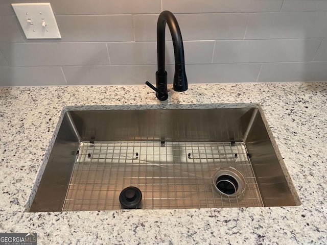 interior details with light stone counters and a sink