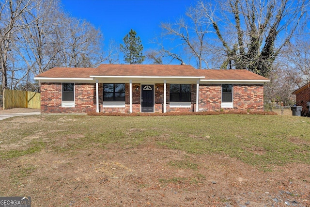 single story home featuring a front lawn, fence, and brick siding