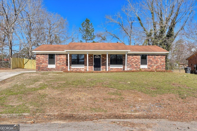 ranch-style home featuring brick siding, a front yard, and fence