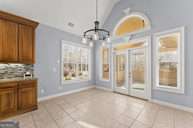 1348 Ewing Creek Dr, Dacula, GA 30019 - unfurnished dining area with a chandelier, lofted ceiling, french doors, and light tile patterned floors