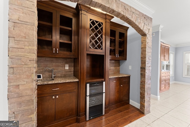 1348 Ewing Creek Dr, Dacula, GA 30019 - indoor bar with ornamental molding, wine cooler, tasteful backsplash, arched walkways, and light tile patterned floors