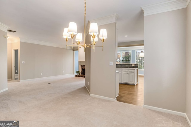 interior space featuring a chandelier, light carpet, a fireplace, baseboards, and ornamental molding