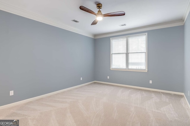 carpeted spare room featuring baseboards, visible vents, ceiling fan, and crown molding