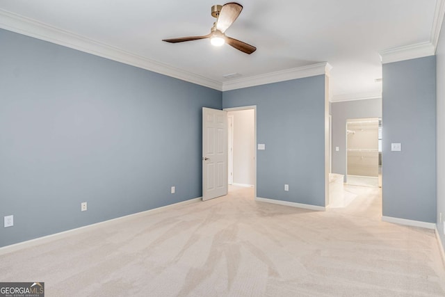 unfurnished bedroom with ornamental molding, a walk in closet, light colored carpet, and baseboards