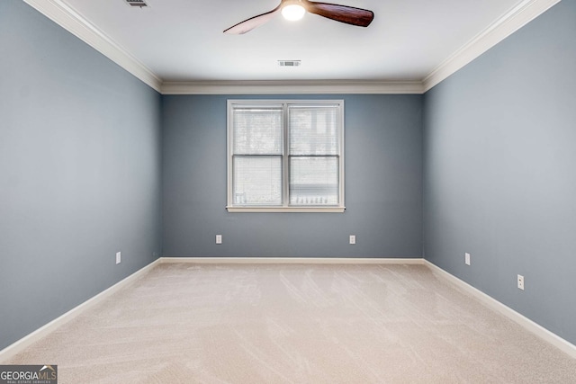 carpeted spare room featuring baseboards, visible vents, a ceiling fan, and ornamental molding