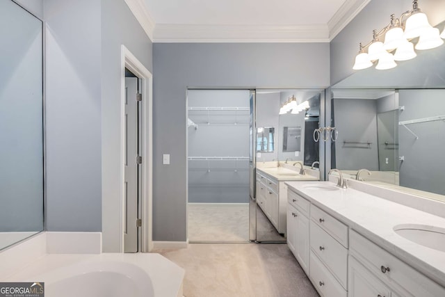 full bath featuring ornamental molding, a walk in closet, a sink, and double vanity