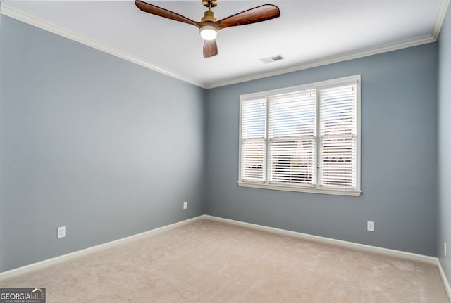 empty room featuring ceiling fan, light carpet, visible vents, baseboards, and ornamental molding