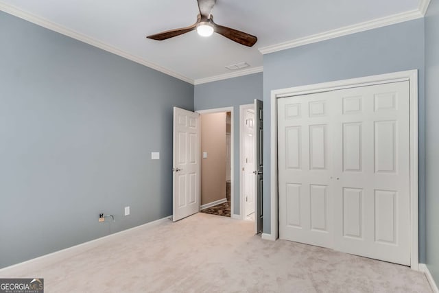 unfurnished bedroom featuring baseboards, visible vents, ornamental molding, carpet floors, and a closet