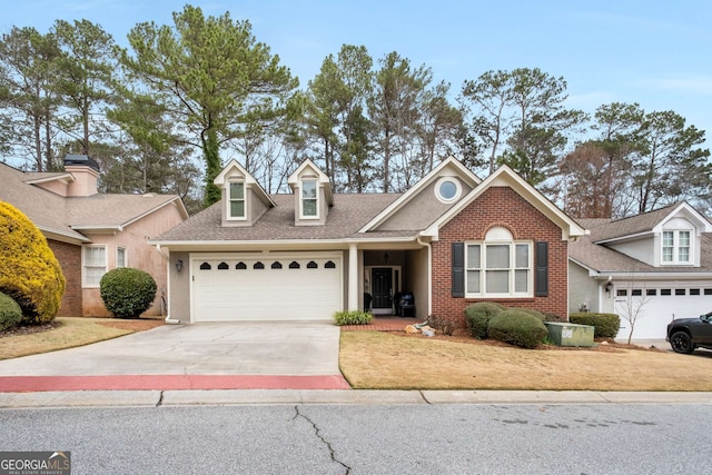 view of front of property featuring a garage, brick siding, a shingled roof, concrete driveway, and stucco siding