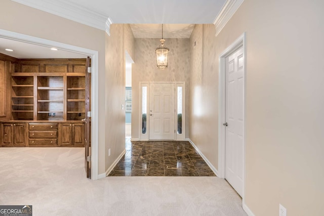 carpeted entrance foyer featuring baseboards and ornamental molding