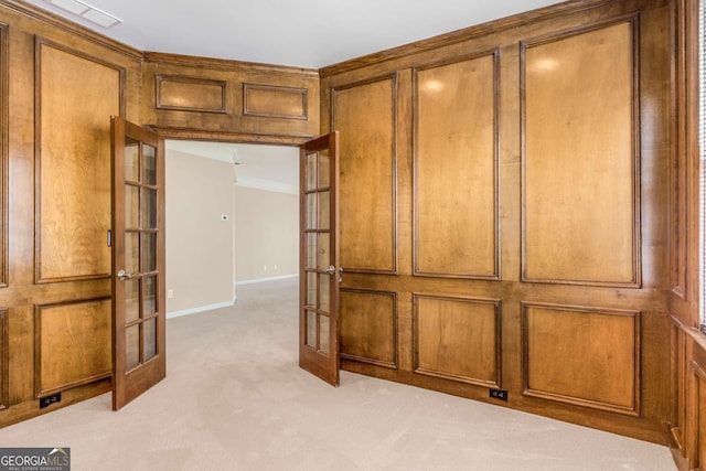 interior space featuring light carpet, french doors, ornamental molding, and baseboards