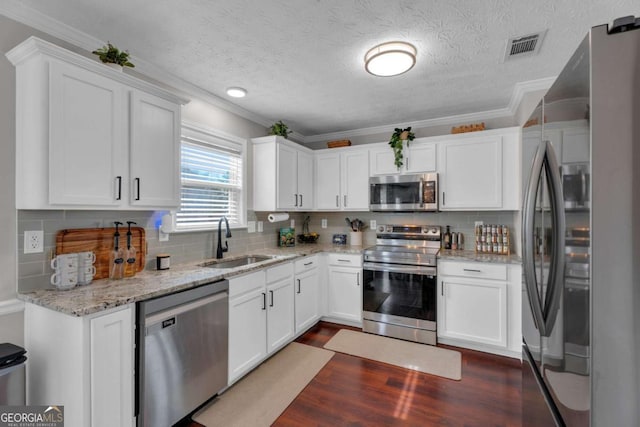 kitchen featuring appliances with stainless steel finishes, white cabinets, and a sink