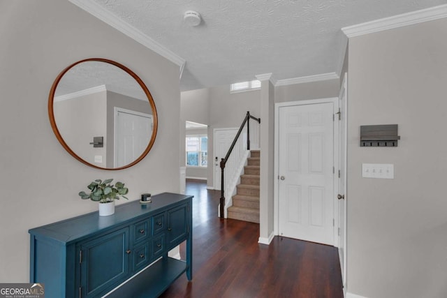 entryway with dark wood-style floors, stairway, a textured ceiling, and ornamental molding