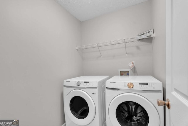 laundry area with a textured ceiling, laundry area, and washing machine and clothes dryer