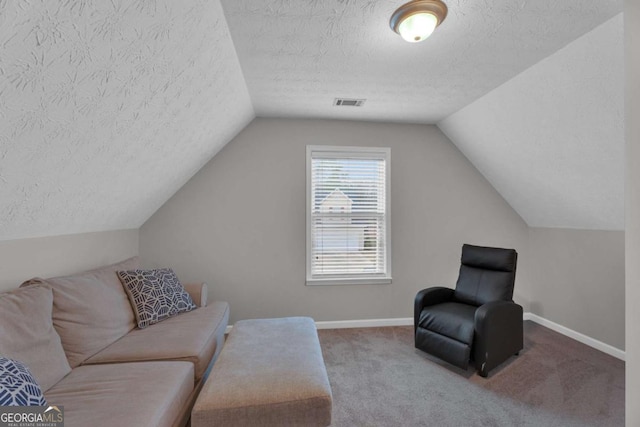 interior space featuring visible vents, vaulted ceiling, a textured ceiling, and baseboards