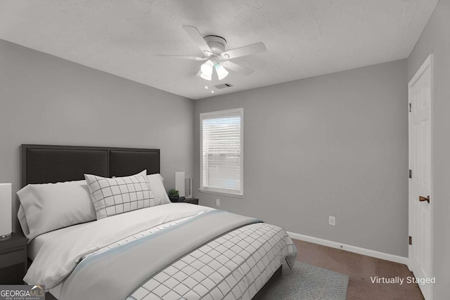 carpeted bedroom with ceiling fan, visible vents, and baseboards