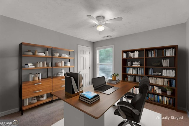 office area featuring a textured ceiling, carpet flooring, visible vents, a ceiling fan, and baseboards