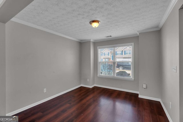 empty room with baseboards, visible vents, dark wood-type flooring, and ornamental molding