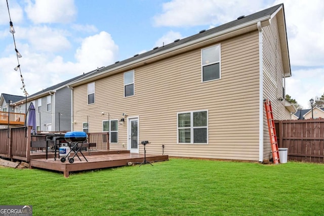 back of property featuring a yard, fence, and a wooden deck