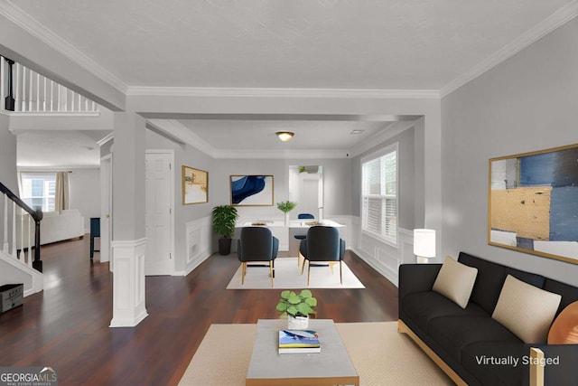 living area with a wainscoted wall, crown molding, stairway, wood finished floors, and ornate columns