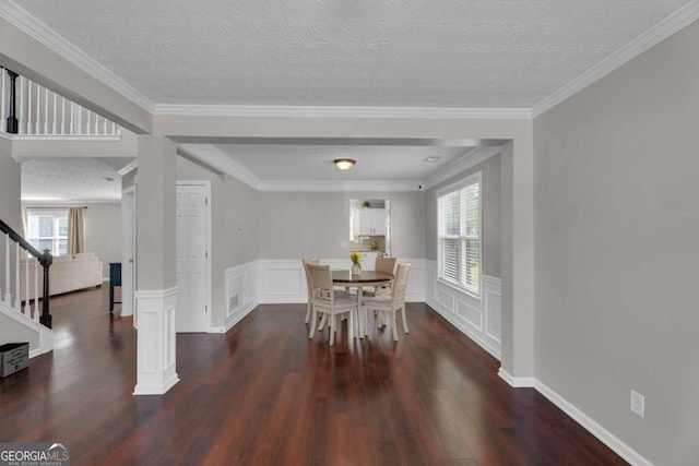 dining room with a textured ceiling, plenty of natural light, stairs, and wood finished floors