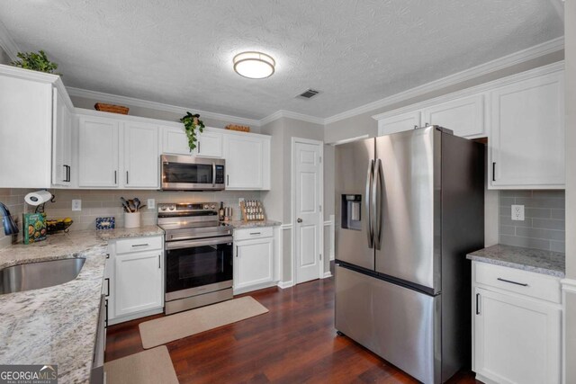 kitchen with visible vents, appliances with stainless steel finishes, dark wood-type flooring, white cabinetry, and a sink