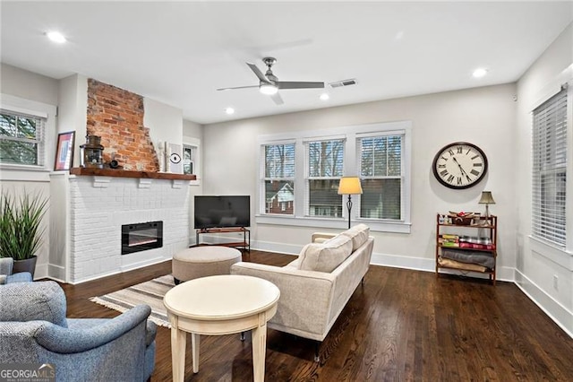 living area featuring baseboards, visible vents, wood finished floors, a fireplace, and recessed lighting