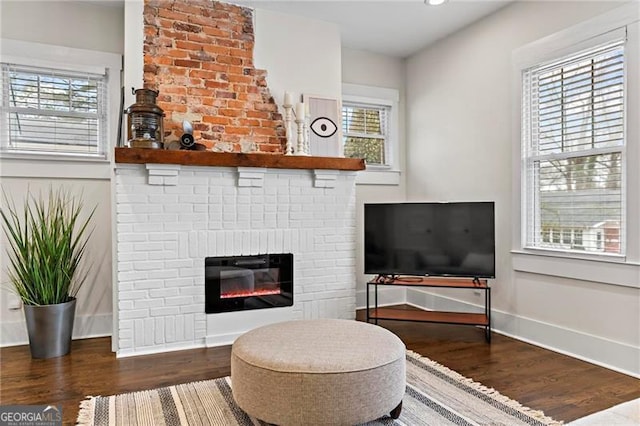 living area featuring plenty of natural light, a fireplace, and wood finished floors