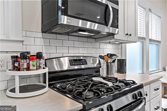 kitchen featuring white cabinetry, appliances with stainless steel finishes, light countertops, and decorative backsplash