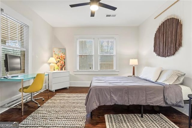 bedroom featuring a ceiling fan, wood finished floors, visible vents, and baseboards